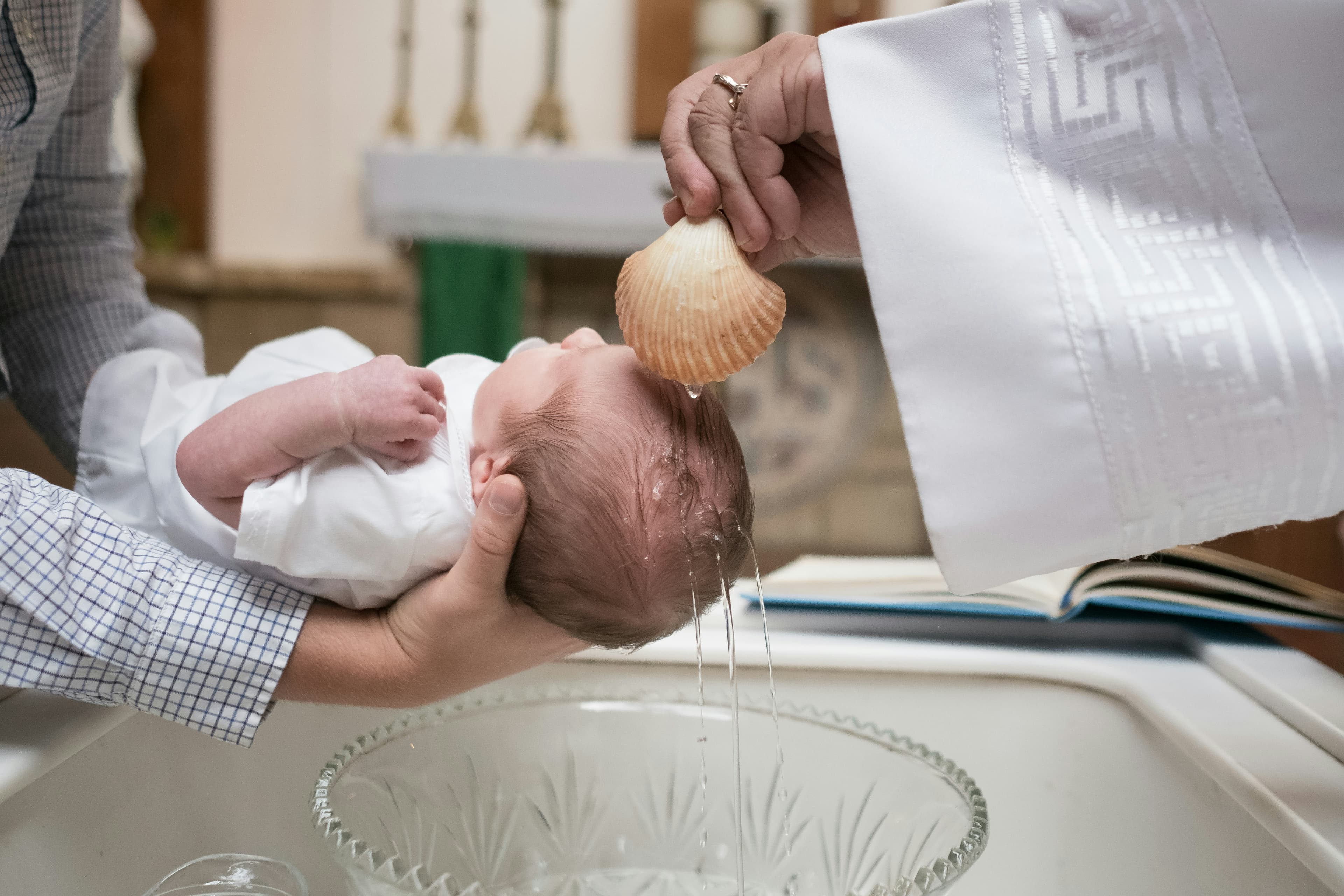 Baptême d'un bébé au-dessus des fonts baptismaux